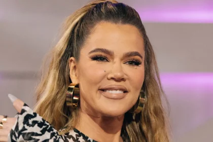 Khloé Kardashian smiling warmly during a photoshoot, exuding confidence and glamour.