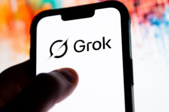 “Grok AI logo displayed on a smartphone screen as regulators investigate the platform over deepfake safety violations.