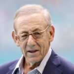 Stephen Ross, owner of the Miami Dolphins, standing on the field inside Hard Rock Stadium, overseeing the venue.